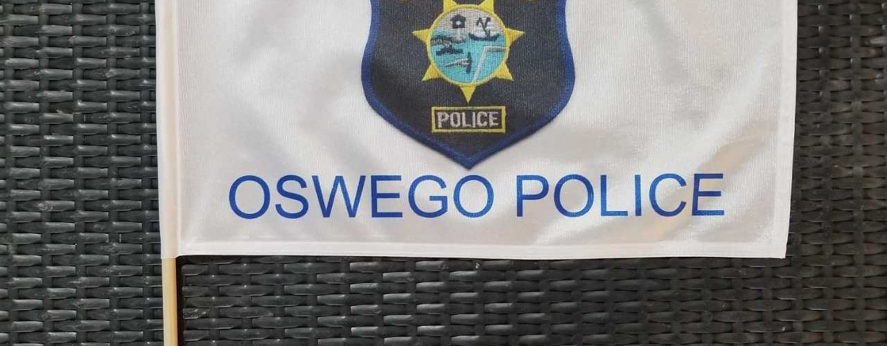 A flag with the words " in memoriam oswego police ".