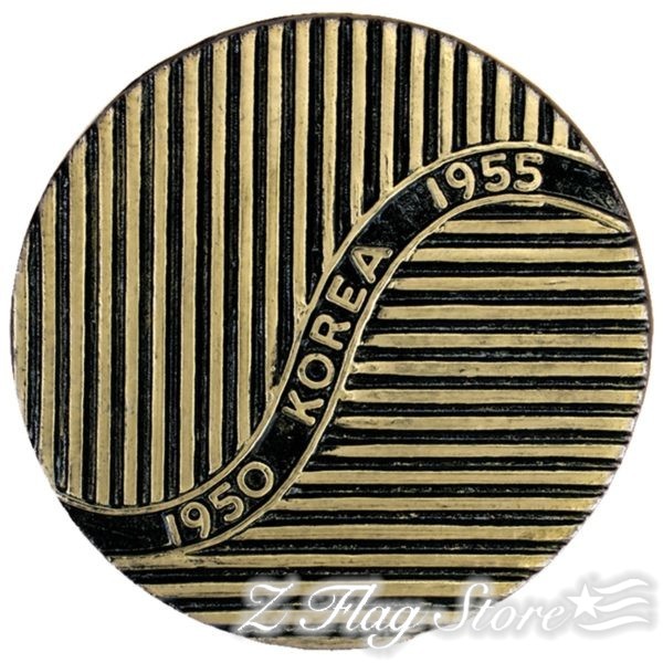 A gold colored coin with black and white stripes.